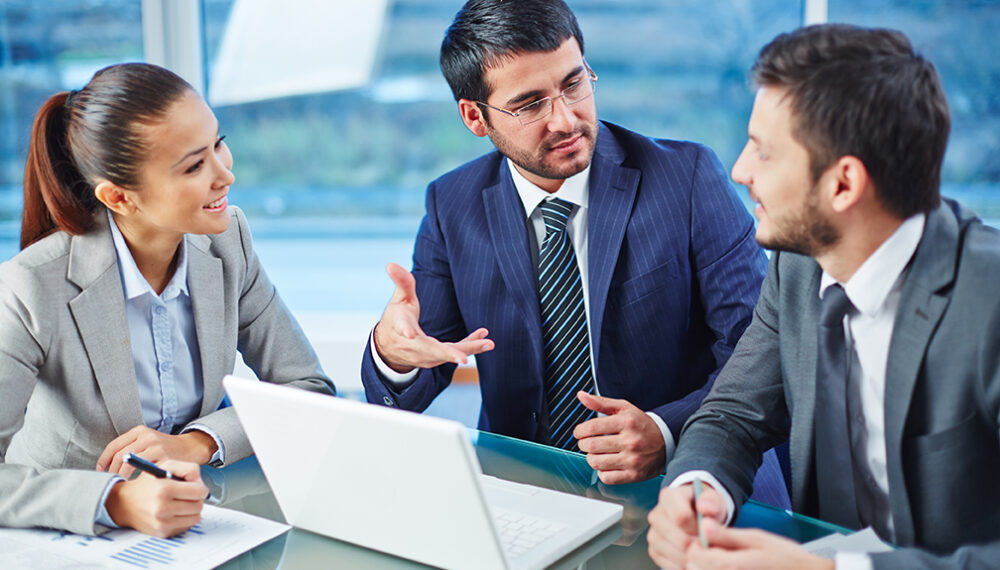 Happy businesspeople explaining colleague the main points of new project