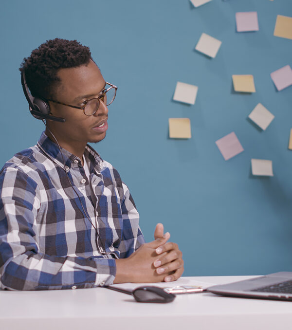 Helpline operator giving telemarketing assistance and support at client care call center, talking on phone call with people. Sales adviser using microphone and headphones at customer service.
