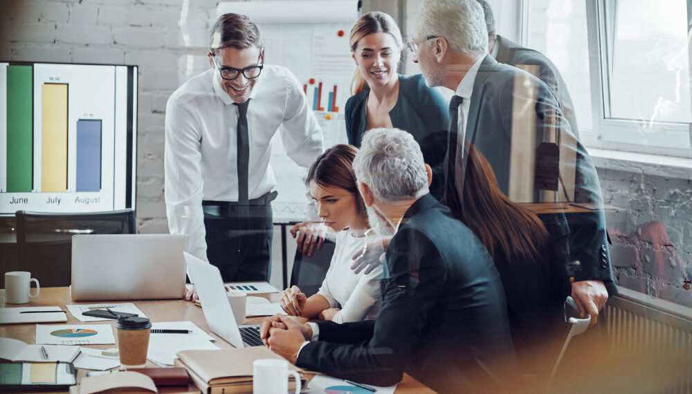 Successful business team analyzing sales while having staff meeting in the board room